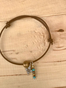 Leather Adjustable Bracelet with Dangling Silver Cross and Gold and Turquoise Colored Beads.